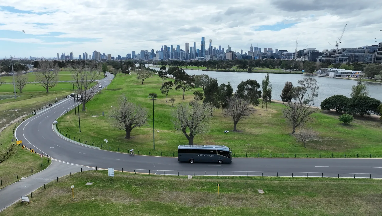 Alston coach passing Albert Park with the Melbourne skyline